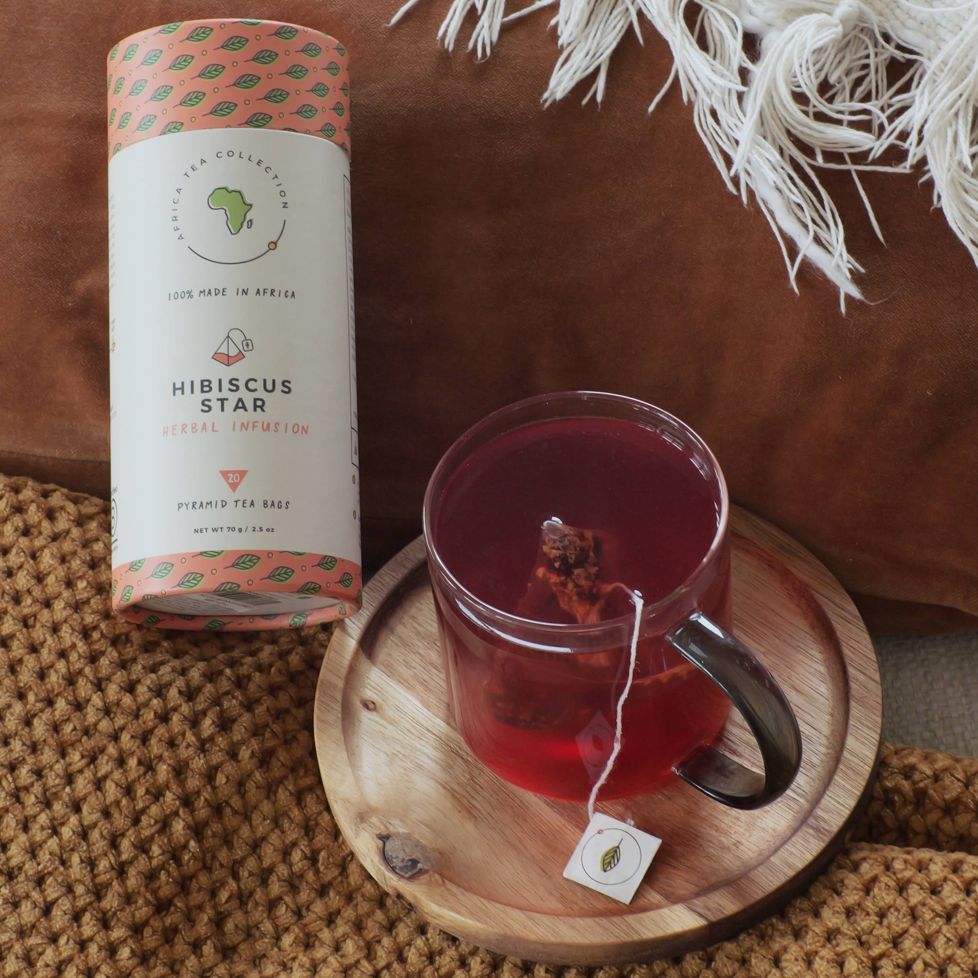 Hibiscus Star tea blend with a cup of tea on a wooden coaster, placed on a textured surface.
