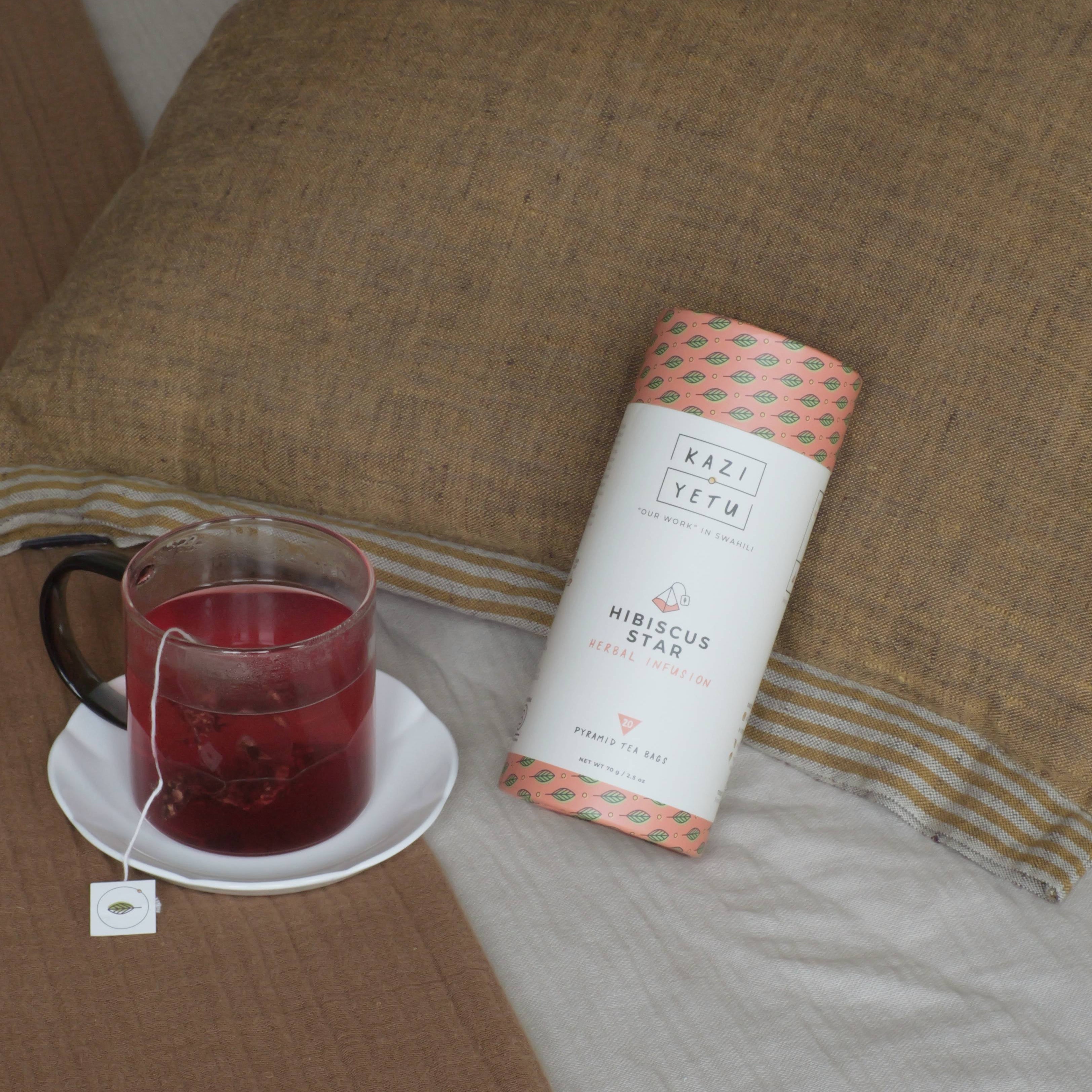 Hibiscus Star tea blend and tea cup in the bed representing a cozy setting.