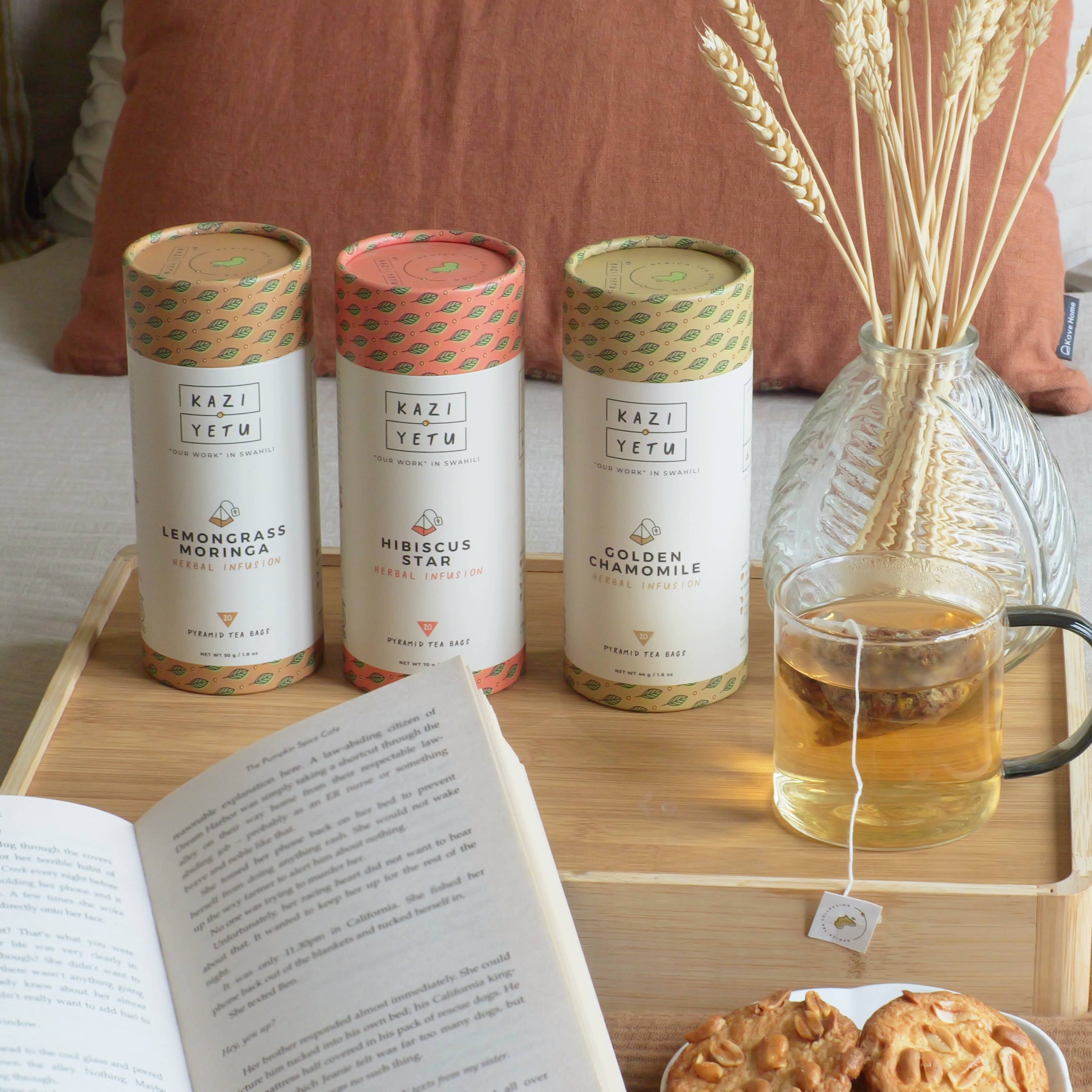Tea blends on a table with a cup of tea and cookies, set against a cozy indoor background.