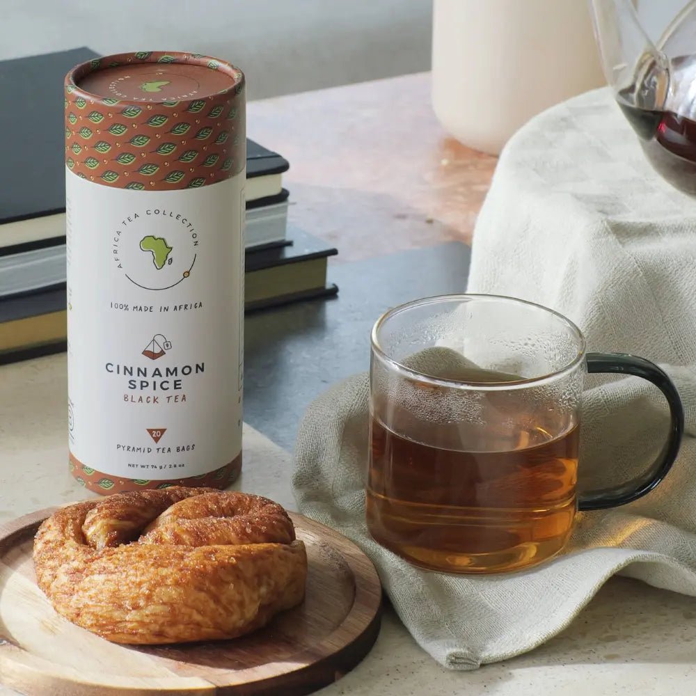 Cinnamon spice black tea blend with a mug of tea and a cinnamon roll on the table.