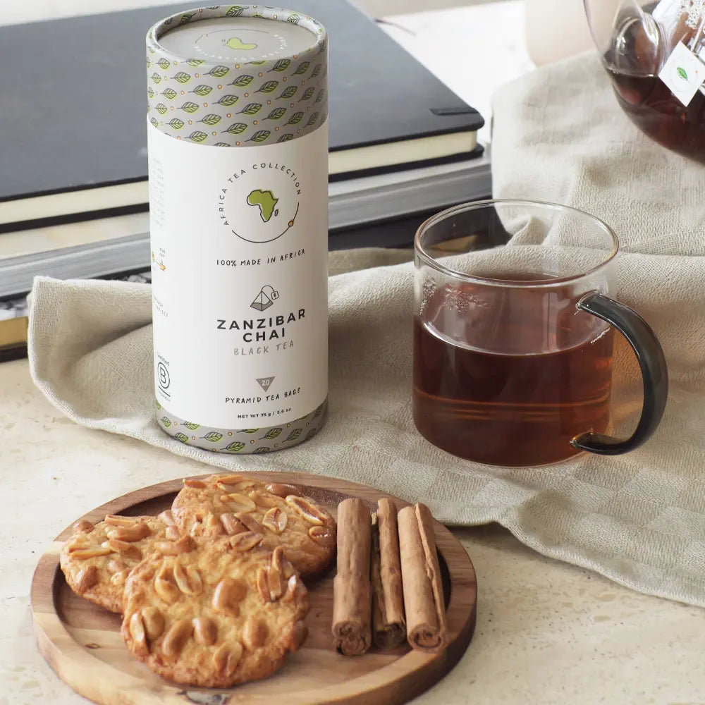 Zanzibar Chai tea blend with a cup of tea and cookies on a wooden board.